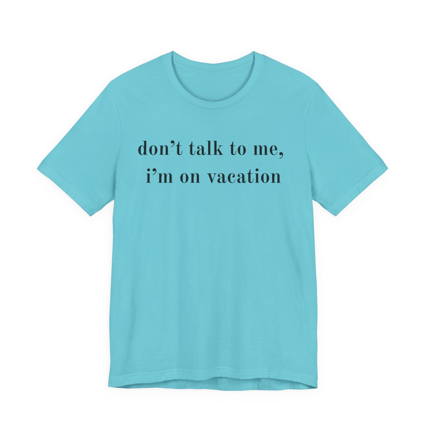 A light blue short-sleeve crewneck t-shirt with the text 'don't talk to me, i'm on vacation' printed in black serif font across the chest, displayed on a solid white background.
