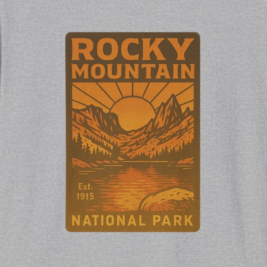 A light heather gray short-sleeve t-shirt with a retro-style orange and brown graphic on the chest reading 'ROCKY MOUNTAIN NATIONAL PARK'.