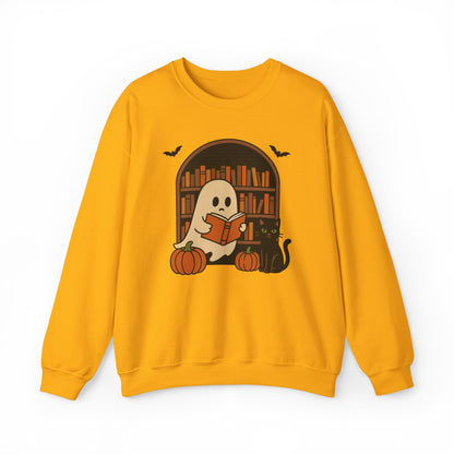 A yellow crewneck sweatshirt featuring a Halloween graphic of a ghost reading a book in front of a bookshelf, with pumpkins, a black cat, and bats.