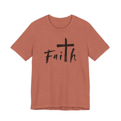 A heathered terracotta short-sleeve t-shirt with a black graphic on the chest featuring a cross and the word 'Faith' in a handwritten font, displayed on a solid white background.
