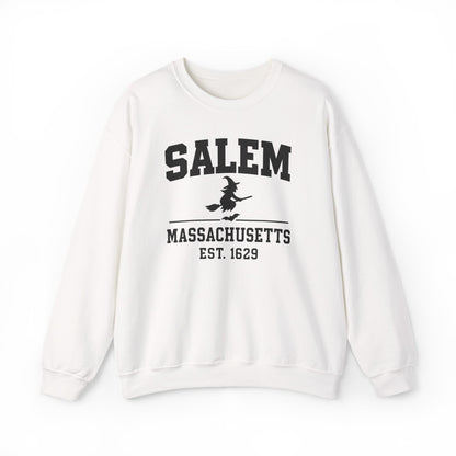 An off-white crewneck sweatshirt featuring a black graphic print on the front that reads 'SALEM MASSACHUSETTS EST. 1629' with a silhouette of a witch riding a broomstick.