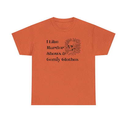 An orange short-sleeve crewneck t-shirt with a black graphic print on the front that reads 'I Like Murder Shows & Gomf Clothes' alongside a skull and roses illustration, shown on a plain white background.