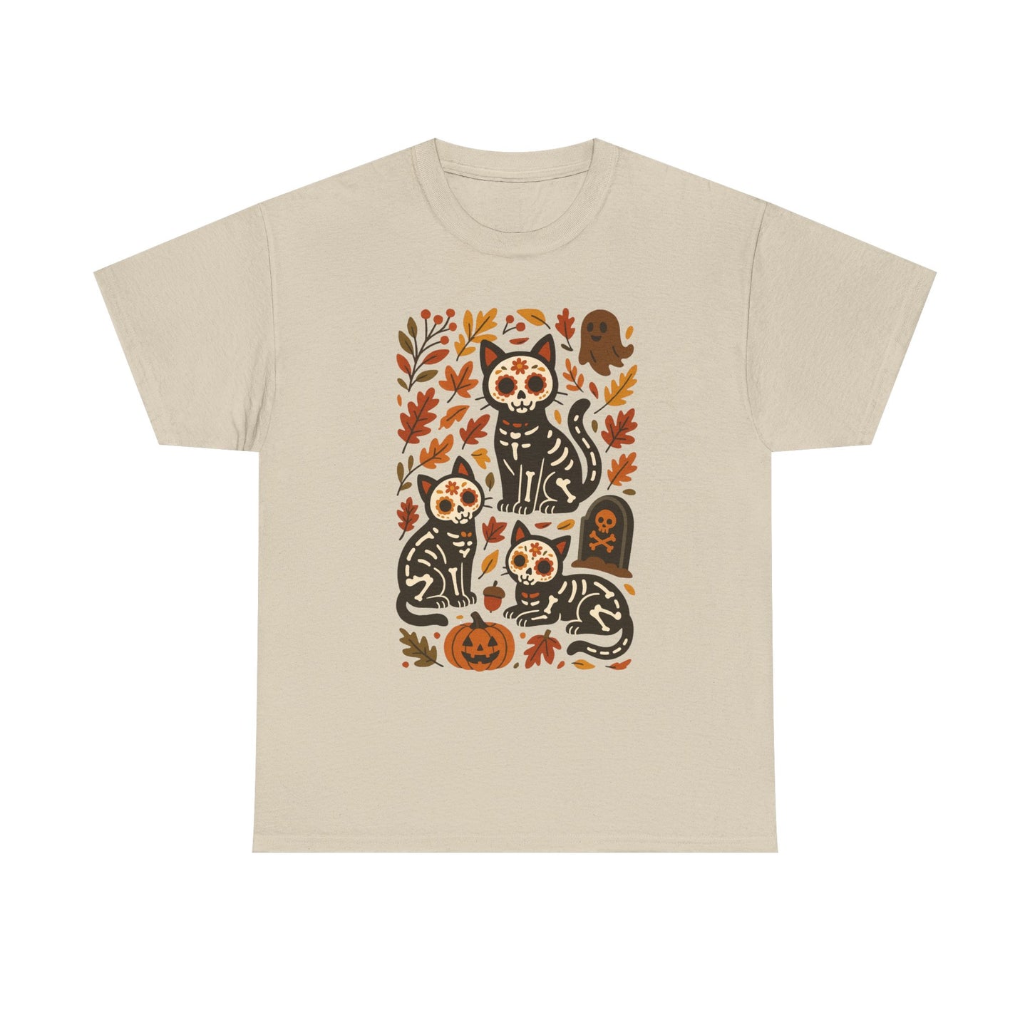 A light beige crewneck t-shirt featuring a central graphic print of four black cats decorated with sugar skull patterns, surrounded by orange and brown autumn leaves, pumpkins, and tombstones.