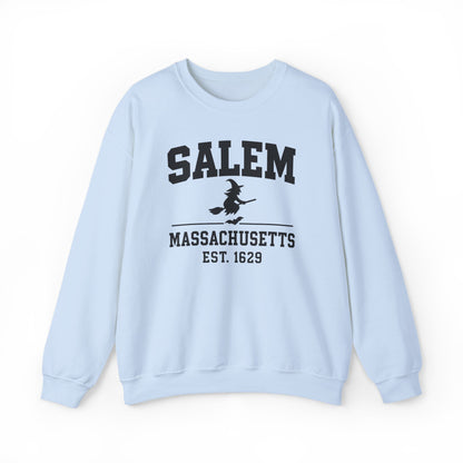 A light blue crewneck sweatshirt featuring a black graphic print on the front that reads 'SALEM MASSACHUSETTS EST. 1629' with a silhouette of a witch riding a broomstick.