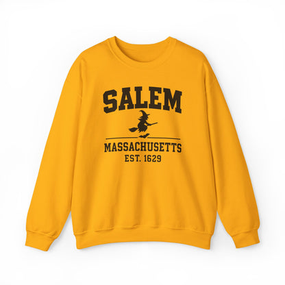 A yellow crewneck sweatshirt featuring a black graphic print on the front that reads 'SALEM MASSACHUSETTS EST. 1629' with a silhouette of a witch riding a broomstick, displayed against a plain white background.
