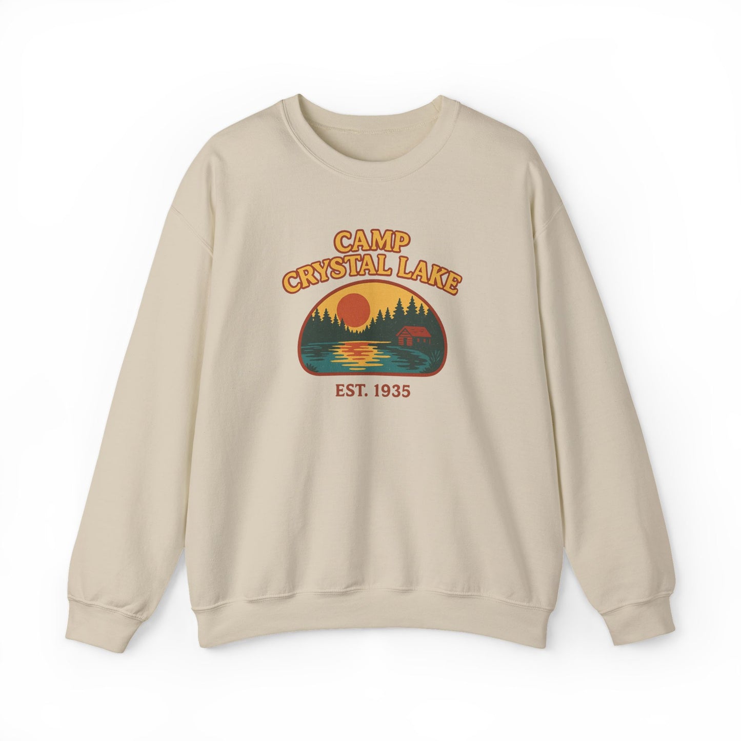 A beige crewneck sweatshirt featuring a retro-style graphic of a campfire scene at Crystal Lake with the text 'CAMP CRYSTAL LAKE' and 'EST. 1935'.