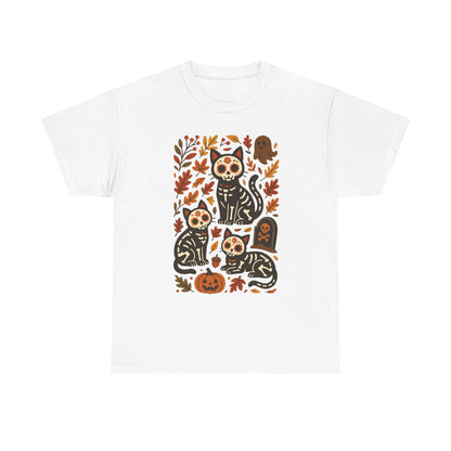 A white short-sleeve crewneck t-shirt featuring a central graphic print of four black cats decorated with sugar skull patterns, surrounded by autumn leaves, pumpkins, and a tombstone.