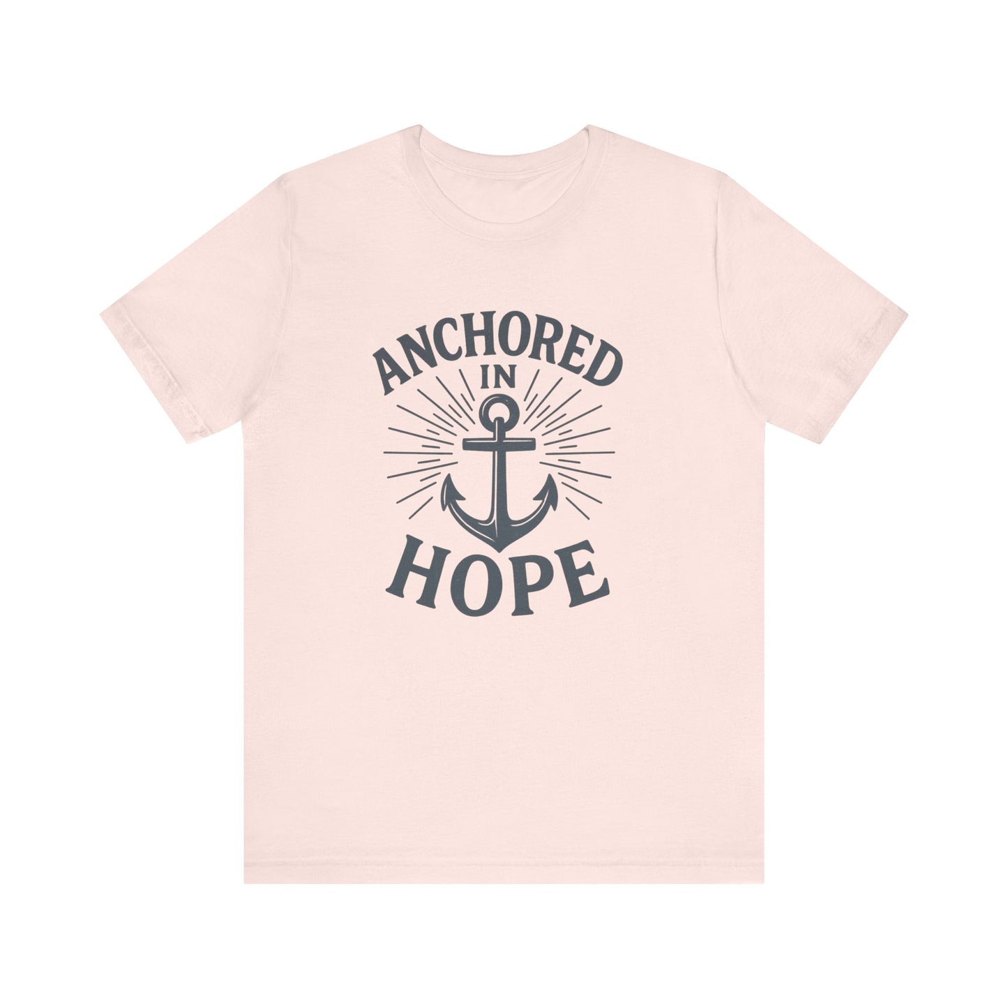 A light pink short-sleeve crewneck t-shirt with a dark gray graphic on the front featuring an anchor and the words 'ANCHORED IN HOPE'.