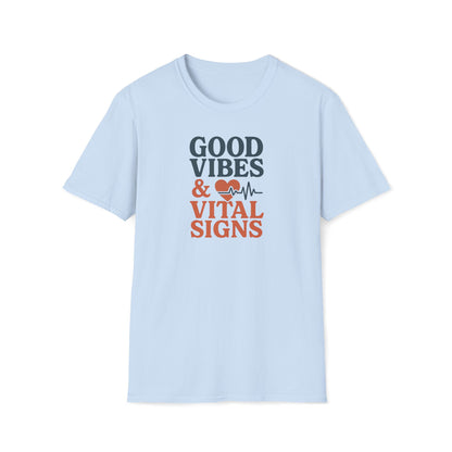 A light blue short-sleeve crewneck t-shirt with a graphic on the chest that reads 'GOOD VIBES & VITAL SIGNS' in dark blue and orange text, accompanied by a heart and heartbeat line icon, shown on a plain white background.