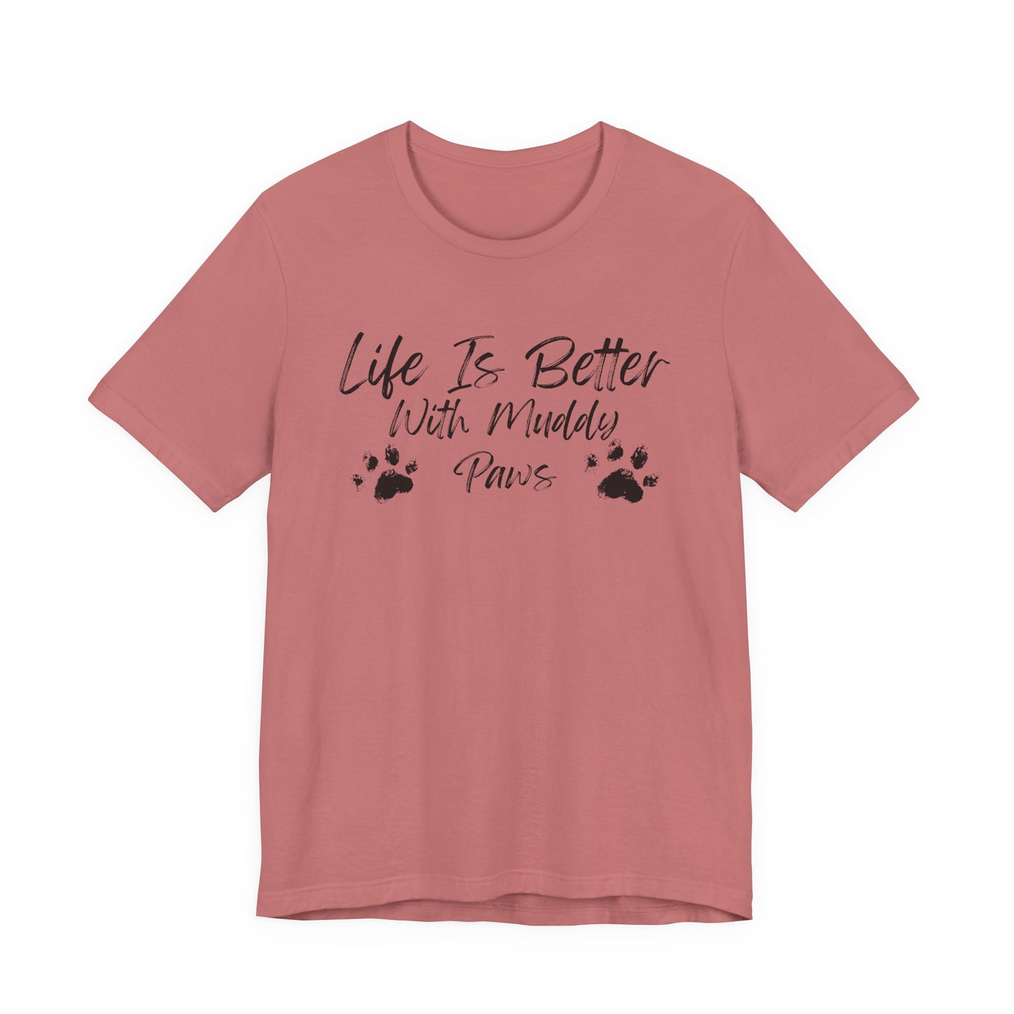 A dusty rose short-sleeve t-shirt with a black graphic print that reads 'Life Is Better With Muddy Paws' accompanied by two paw prints, shown on a plain white background.