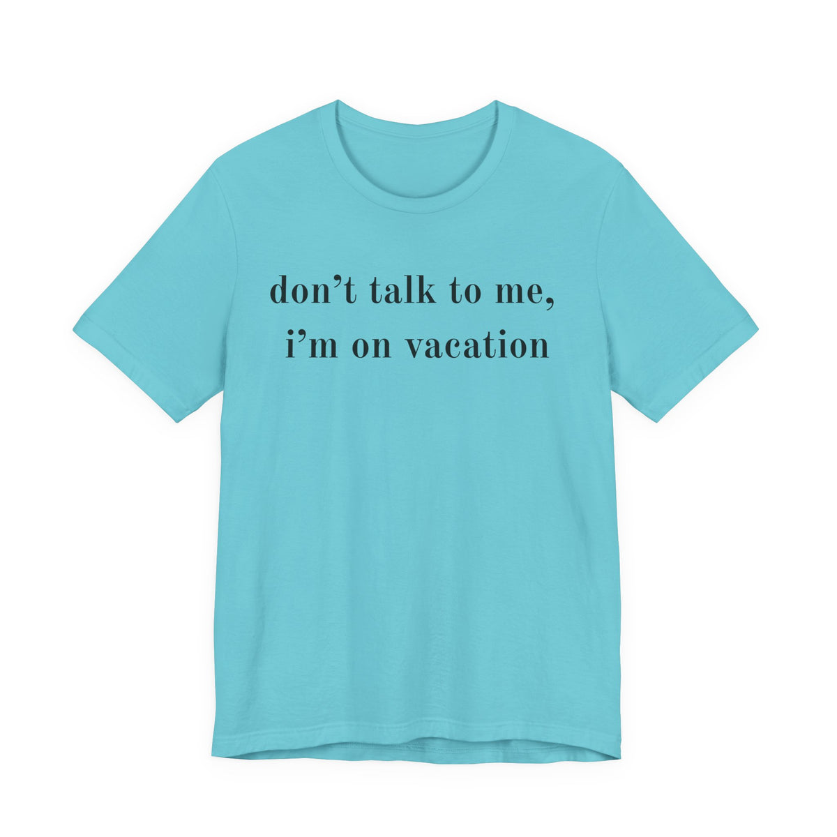 A light blue short-sleeve crewneck t-shirt with the text 'don't talk to me, i'm on vacation' printed in black serif font across the chest, displayed on a solid white background.
