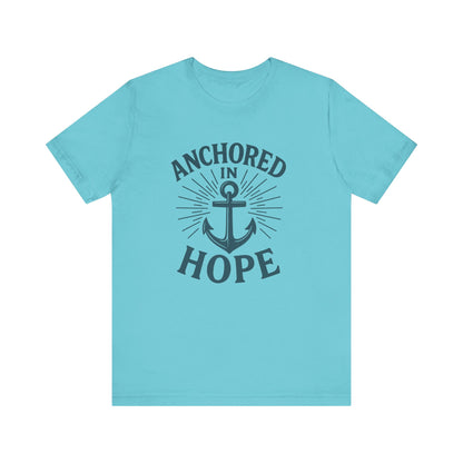 A light blue short-sleeve crewneck t-shirt with a dark navy graphic on the front featuring an anchor and the words 'ANCHORED IN HOPE'.