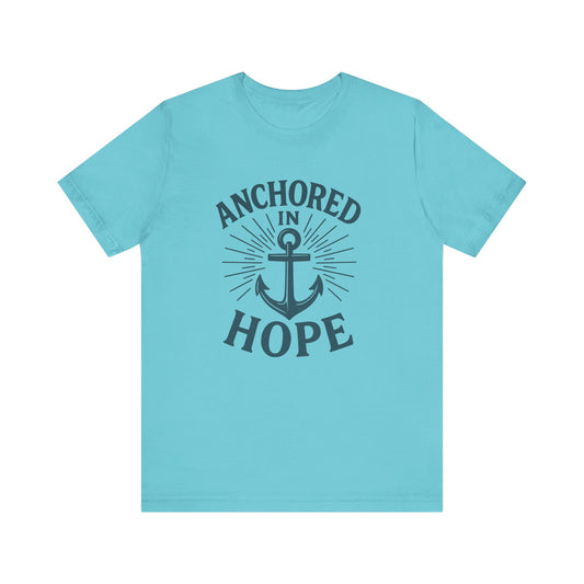 A light blue short-sleeve crewneck t-shirt with a dark navy graphic on the front featuring an anchor and the words 'ANCHORED IN HOPE'.