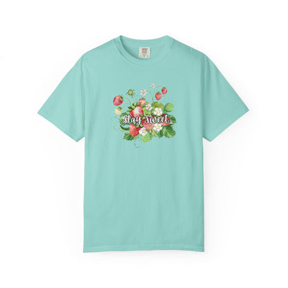 A light turquoise short-sleeve crewneck t-shirt featuring a colorful floral graphic on the chest with strawberries and the text 'Stay Sweet'.