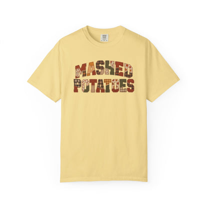 A pale yellow short-sleeve t-shirt with 'MASHED POTATOES' printed across the chest in a rustic brown and beige patterned font, displayed on a clean white background.