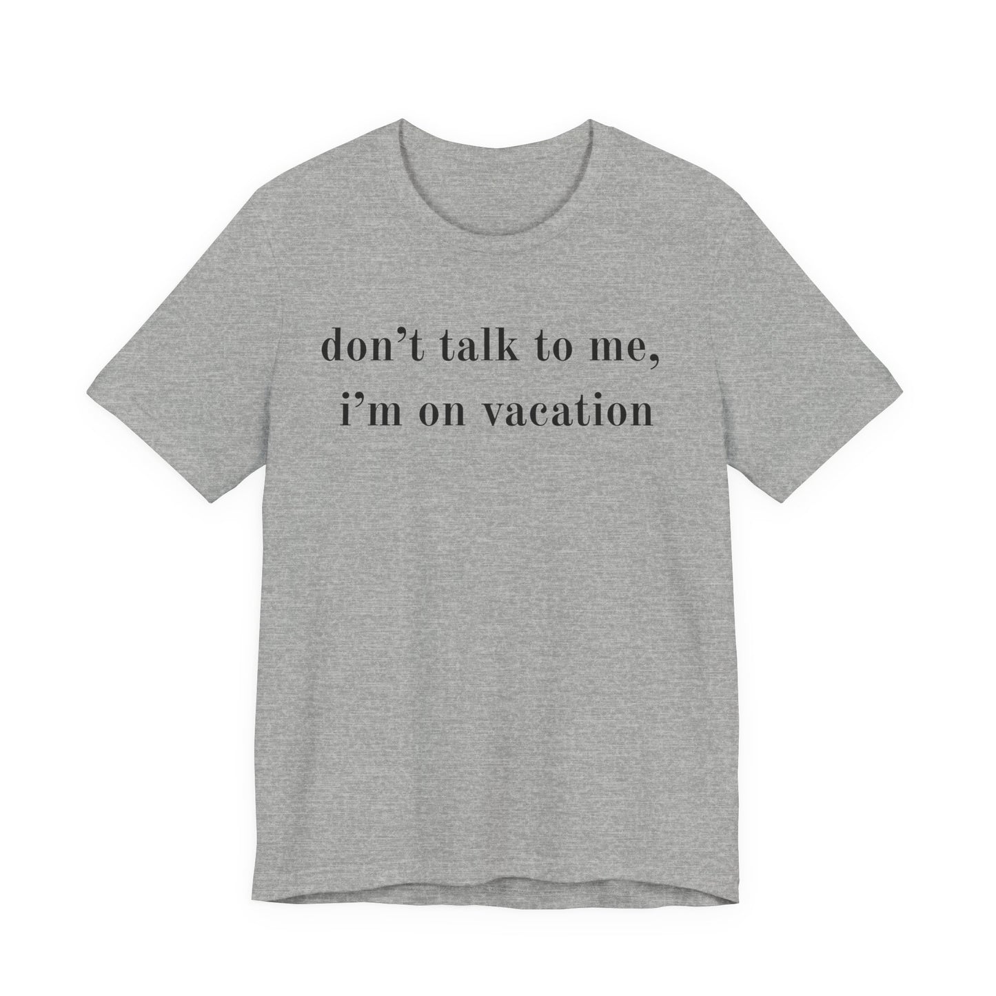 A heather gray short-sleeve t-shirt with the text 'don't talk to me, i'm on vacation' printed in black lowercase serif font across the chest, displayed on a solid white background.