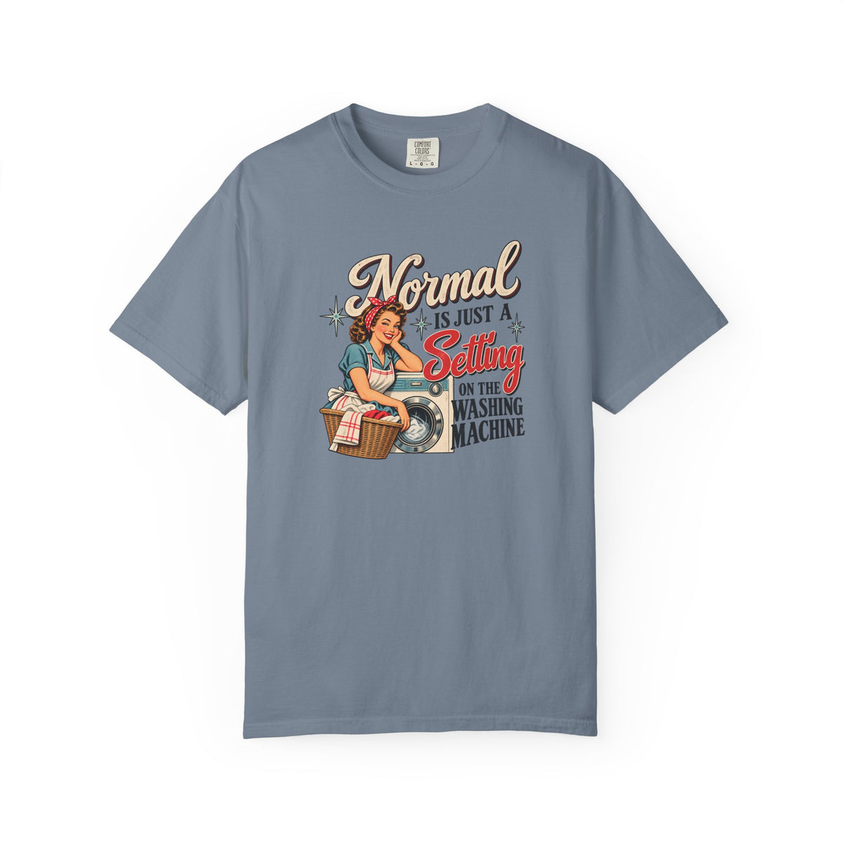 A slate blue short-sleeve t-shirt with a vintage-style graphic of a pin-up woman washing a shirt, accompanied by the text 'Normal is just a Setting for the Washing Machine'.