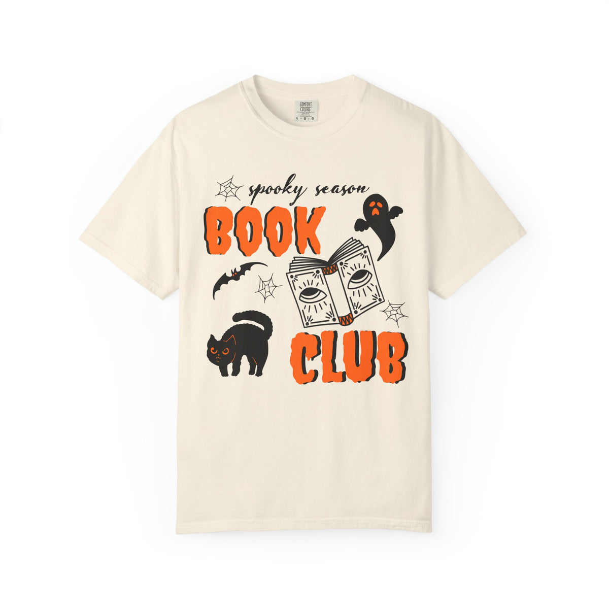 An off-white short-sleeve crewneck t-shirt featuring a 'spooky season BOOK CLUB' graphic with orange text, a cartoon book, a black cat, and a ghost on a plain white background.
