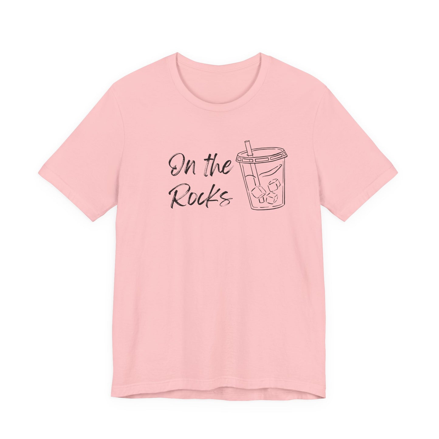 A light pink short-sleeve crewneck t-shirt with a black graphic print on the front that reads 'On the Rocks' next to a simple line drawing of a iced coffee cup, shown against a plain white background.