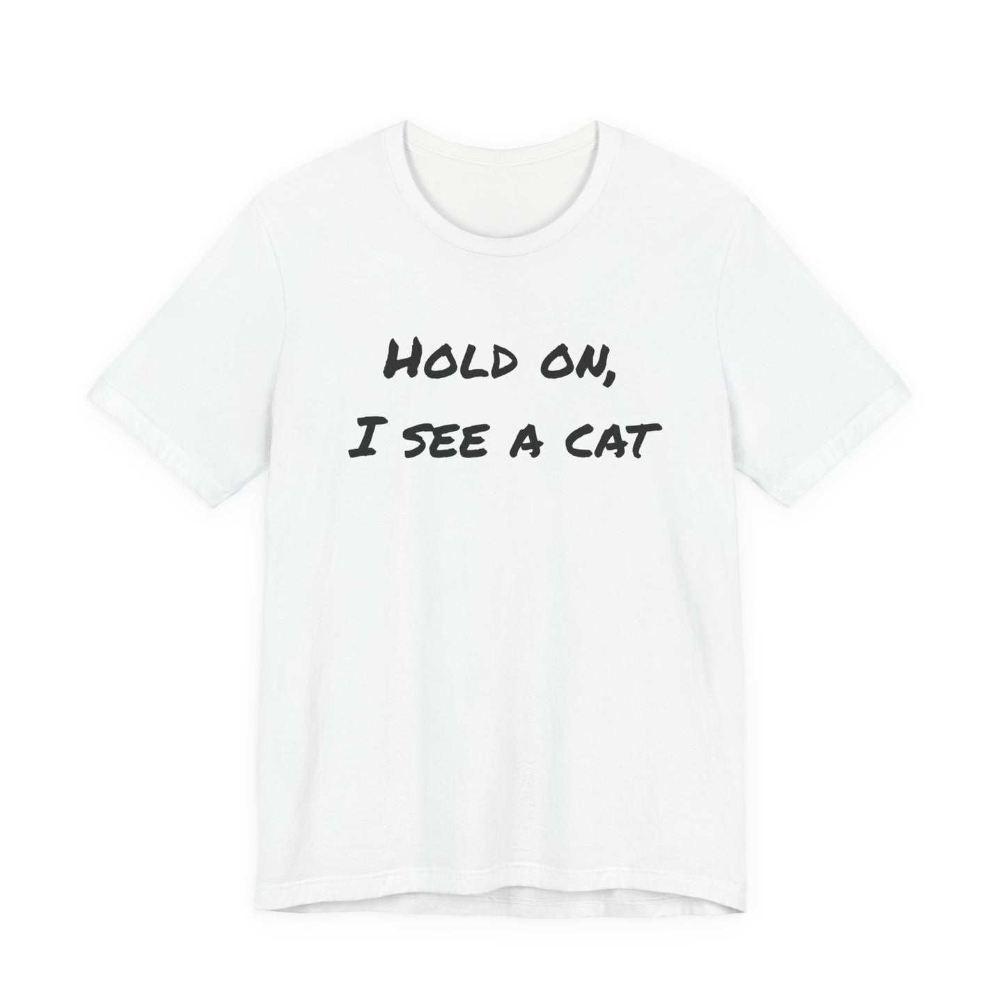 A white short-sleeve crewneck t-shirt with the text 'HOLD ON, I SEE A CAT' printed in a black handwritten-style font across the chest, displayed on a solid white background.