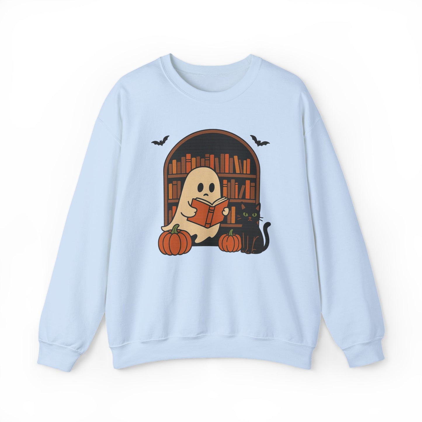 A light blue crewneck sweatshirt featuring a Halloween-themed graphic of a ghost reading a book in front of a library bookshelf, with pumpkins, a black cat, and bats.