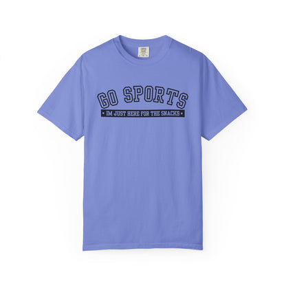 A light blue short-sleeve t-shirt with a dark navy graphic on the chest that reads 'GO SPORTS' and 'I'M JUST HERE FOR THE SNACKS'.