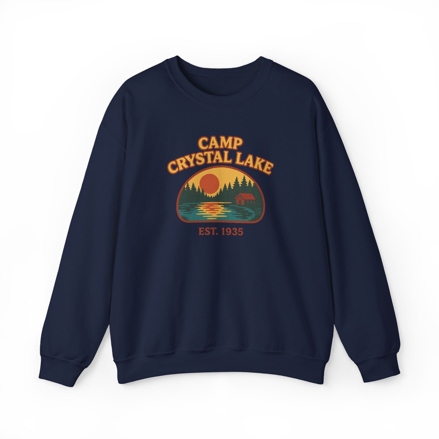 A navy blue crewneck sweatshirt featuring a retro-style 'Camp Crystal Lake' graphic on the chest with a sunset, trees, and a bear, set against a plain white background.