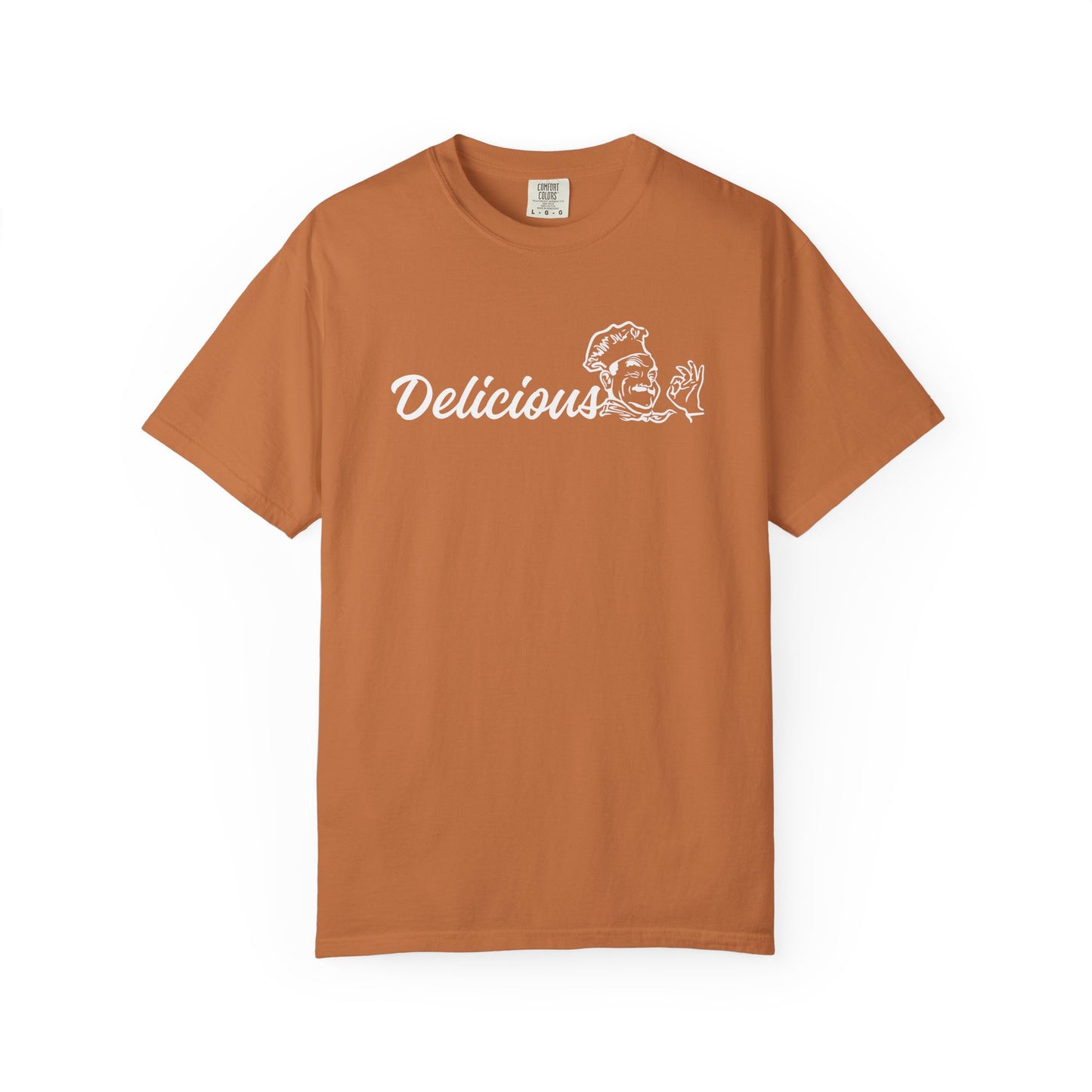 A rust-orange short-sleeve crewneck t-shirt with a white graphic print on the chest reading 'Delicious' next to a cartoon chef illustration, displayed on a clean white background.