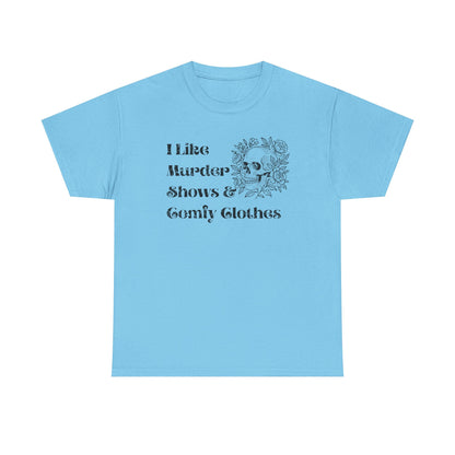 A light blue short-sleeve t-shirt with a black graphic print on the front that reads 'I Like Murder Shows & Gomf Clothes' alongside a skull and roses illustration, displayed on a solid white background.