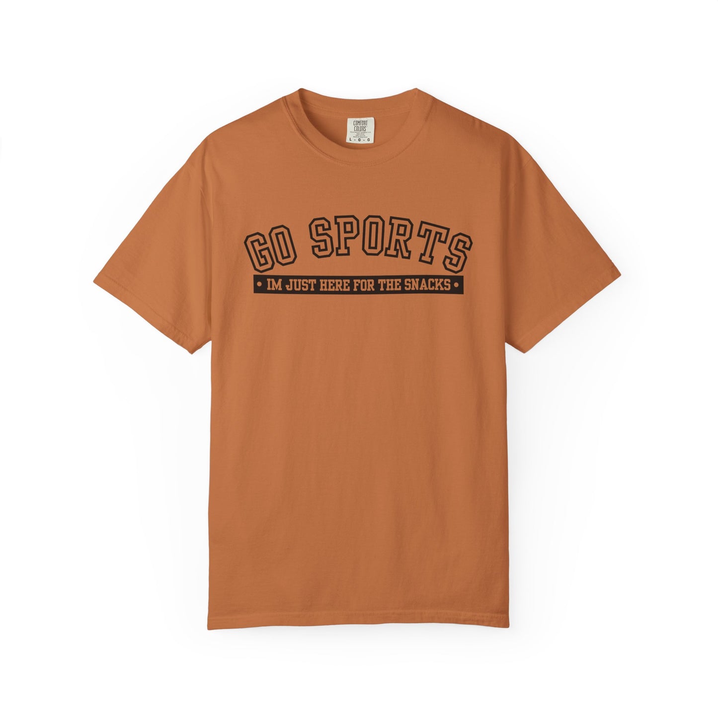 A rust-orange short-sleeve t-shirt with a black graphic on the chest that reads 'GO SPORTS' and 'I'M JUST HERE FOR THE SNACKS'.