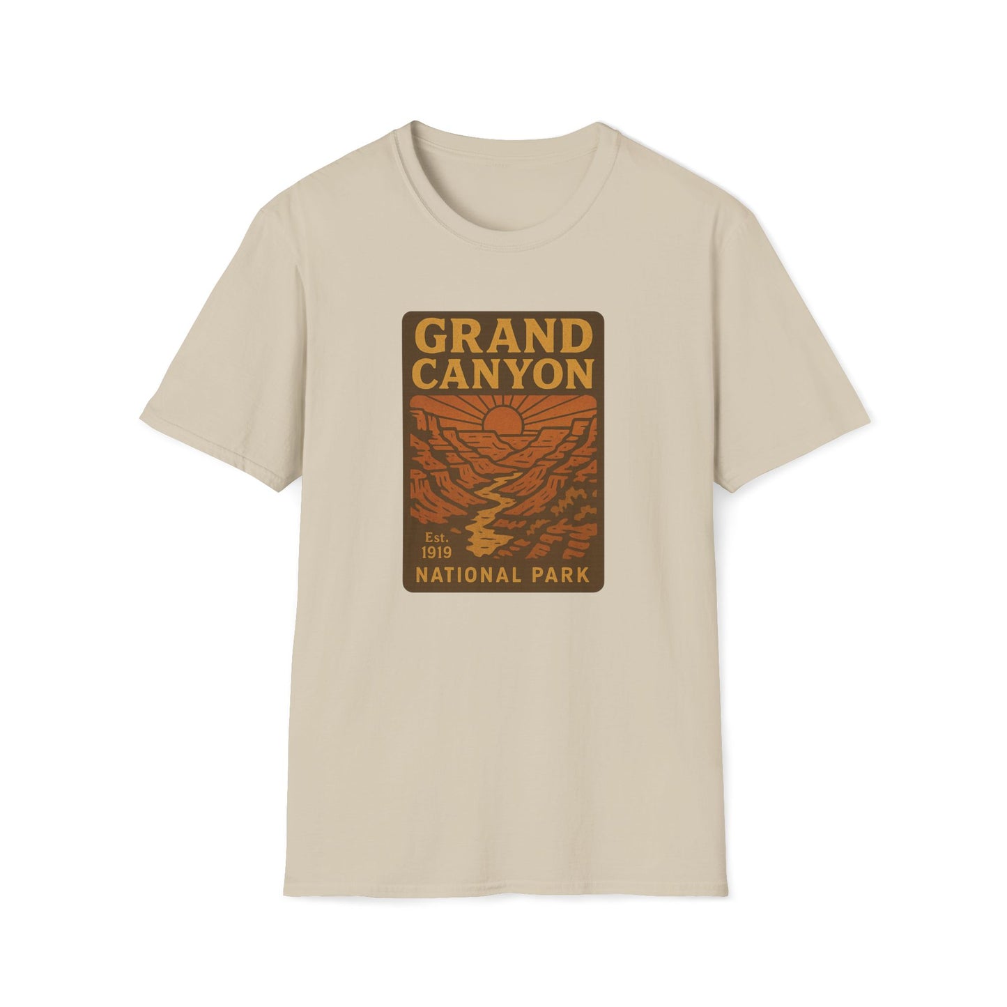 A beige crewneck t-shirt featuring a rectangular graphic print on the chest that reads 'GRAND CANYON NATIONAL PARK' in yellow and brown over an orange canyon landscape illustration.