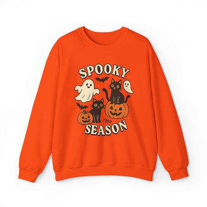 An orange crewneck sweatshirt featuring a 'Spooky Season' graphic with cartoon ghosts, black cats, pumpkins, and bats on a white background.