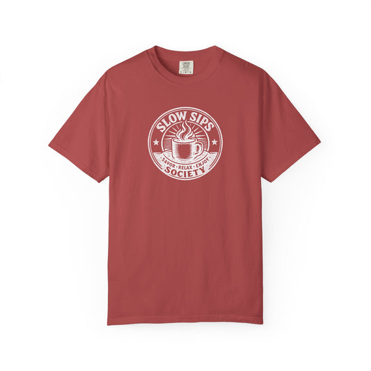 A dusty red short-sleeve crewneck t-shirt with a white circular graphic on the chest that reads 'SLOW SIPS SOCIETY' around an illustration of a coffee cup.