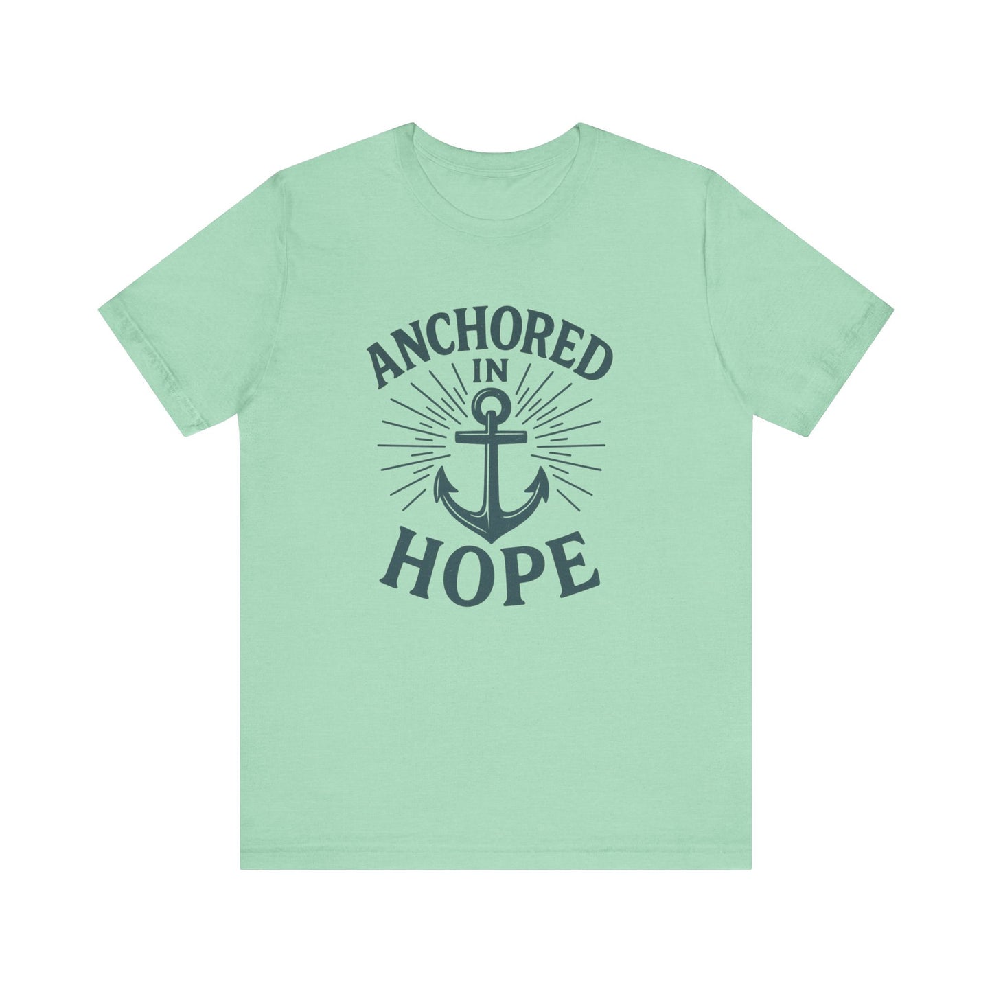 A mint green short-sleeve t-shirt with a dark navy graphic on the front featuring an anchor and the words 'ANCHORED IN HOPE'.