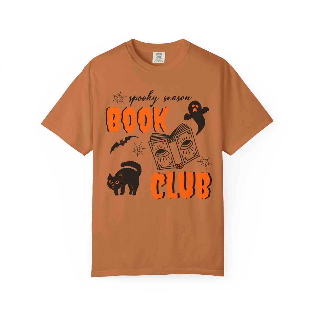 A rust-orange crewneck t-shirt featuring a 'spooky season BOOK CLUB' graphic in black and orange, complete with illustrations of a book, ghost, cat, and bat on a white background.