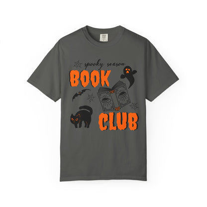 A dark gray crewneck t-shirt featuring a 'spooky season BOOK CLUB' graphic with orange text, a black cat, a ghost, and a book illustration on a white background.