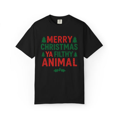 A black short-sleeve crewneck t-shirt with a festive graphic on the chest reading 'MERRY CHRISTMAS YA FILTHY ANIMAL' in red and green text, accented with small green pine trees and holly leaves, shown on a plain white background.