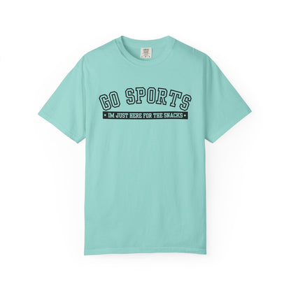 A light mint green short-sleeve t-shirt with a black graphic on the chest that reads 'GO SPORTS' and 'I'M JUST HERE FOR THE SNACKS'.