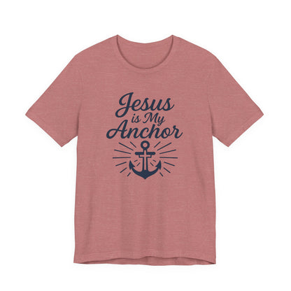 A heathered dusty rose short-sleeve t-shirt with a navy blue graphic on the front that reads 'Jesus is My Anchor' above an anchor design with sunburst rays.