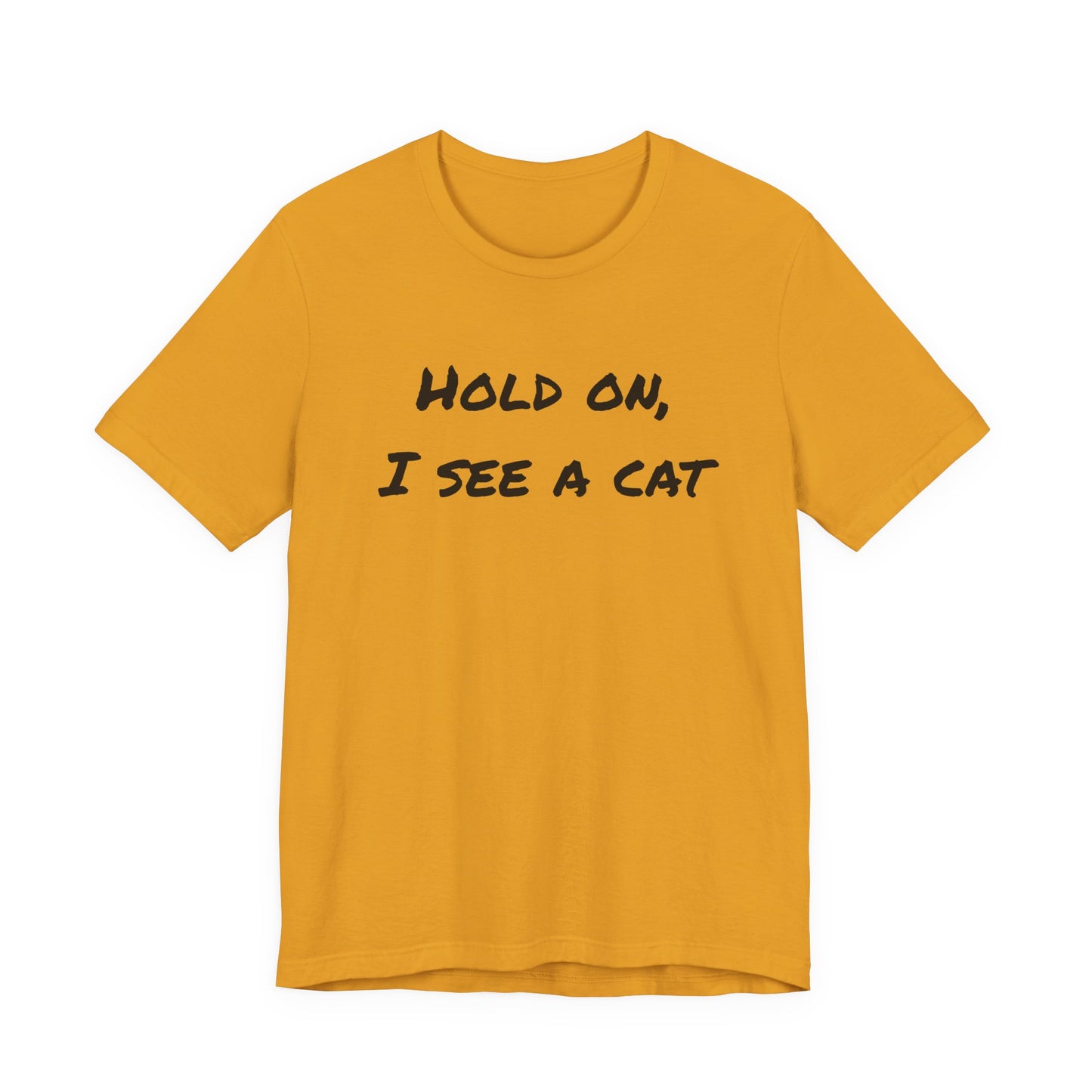 A mustard yellow short-sleeve t-shirt with the text 'HOLD ON, I SEE A CAT' printed in black across the chest, displayed on a solid white background.