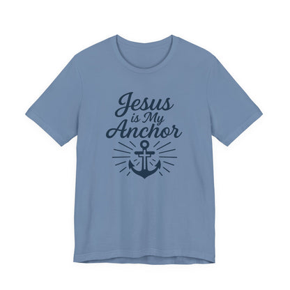 A light blue short-sleeve crewneck t-shirt with a dark navy graphic on the front that reads 'Jesus is My Anchor' above an anchor illustration with sunburst rays.