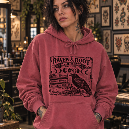 woman in tattoo shop wearing Raven & Root apothecary Sweatshirt from Comfort Colors in Crimson color.
