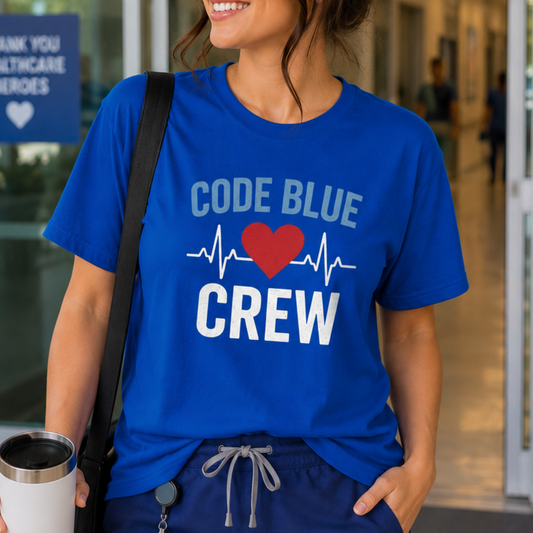 A woman wearing a royal blue graphic t-shirt with 'CODE BLUE CREW' and a red heart printed on the front, paired with navy drawstring sweatpants and a black shoulder bag.